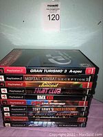 Stack of 10 PlayStation 2 game cases showing spines and part of cover art.