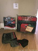 Full lot showing BBQ belt unboxed, red collapsible cooler in packaging, and Britax Kick Mats in packaging