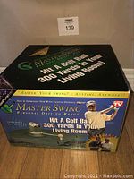 Photo of the Master Swing Personal Driving Range boxed golf swing training aid showing the box front that states hitting a golf ball 300 yards in your living room