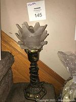 Full view of the vintage table lamp showing frosted glass flower-shaped shade and decorative metal base.