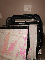 Photo of folded and stacked reversible sequin storage cubes showing black, silver, white and pink sequin surfaces.