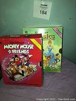 Photo of two Walt Disney book sets, including "Mickey Mouse and Friends" and "Classics Best-Loved Tales". Books are worn.
