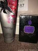 Photo showing both Outspoken by Fergie black boxed perfume and silver tube of Outspoken Intense body lotion with floral graphics.