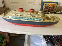 Full side view of the toy steamship showing detailed lithography and battery compartments.