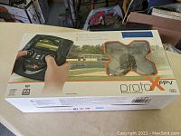 Sealed retail box of Proto X FPV HD micro quadcopter showing the drone through a clear window and image of controller on the box.