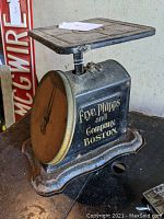 Three-quarter view of the black cast iron scale showing Frye Phipps and Company Boston gold lettering on the side.