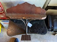 Full front view of the shelf showing the wrought iron buggy step support mounted under the wooden shelf.