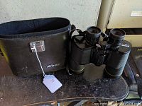 Nikon binoculars shown next to the carrying case, displaying the full set included in the lot.