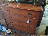 Front view of antique wooden dresser showing four large drawers with original brass drawer pulls and keyholes.