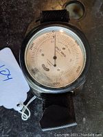 Front view of the Peet Bros. altimeter showing the white dial with altitude markings and jewel count indicator