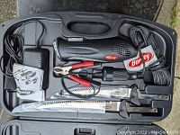 Complete Berkley electric fillet knife set in hard plastic case, showing motorized handle, two blades, charger and cords neatly arranged inside the case.