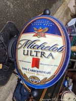 Front view of the oval Michelob Ultra lighted sign showing logo and beer details.
