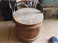 Overall top view of antique wooden firkin showing aged wood top and handle
