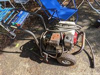 Full view of Ex-Cell pressure washer with metal frame, wheels, and engine mounted.