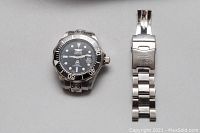 Watch with detached band side-by-side on a plain background to show condition and parts.