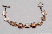 Full view of the 925 silver bracelet with textured links and amber glass beads on a gray background.