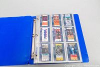 Blue binder open to pages with ticket stub style 1991 baseball draft pick cards, multiple cards per page, stored in plastic sleeves.