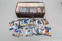 Shoebox filled with a large assortment of NHL hockey cards with various players and teams displayed on top.