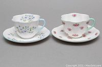 Two Shelley china teacups with matching saucers, showing floral patterns and scalloped edges, placed side by side.