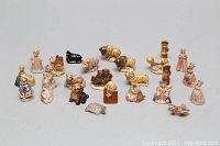 Overview of entire lot showing 25 Wade miniature ceramic figurines including animal and human figures