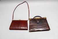 Two vintage leather purses displayed side-by-side, showing overall size and texture contrast between snake and crocodile patterns.