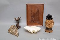 Photo showing all items: framed wood wall art, pineapple candle holder, shell bowl, and metal wall sculpture.