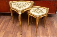 Two Florentine Italian nesting tables side by side showing overall shape, size difference, and wear on legs and edges.
