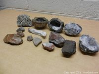 Collection of various rocks and several geodes showing natural rough exteriors and cut interiors revealing crystals