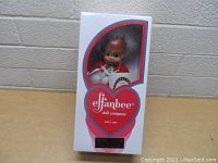 Photo of Effanbee Patsy doll in original white box with red and blue trim, showing front of box and doll inside.