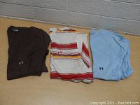 Three folded Hang Ten shirts side by side: brown, white with stripes, and light blue.