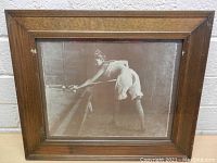 Front view of the framed vintage black and white photograph showing a woman playing pool.