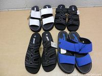 Top down view of four pairs of women's Baywatch brand slip-on shoes, showing different strap designs in white, black, and blue colors.