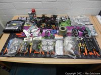Top-down view showing RC car parts arranged on a work mat including wheels, electronics, and tools.