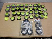 Full overview of all 42 RC car tires laid on a table, mostly mounted on yellow rims, with three sealed packages of additional tires visible.