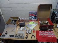 Overview of table with RC car parts, oils, tools, wheels, and decals
