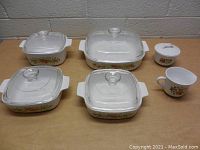 Top-down view of all dishes and cups showing floral patterns and clear glass lids.