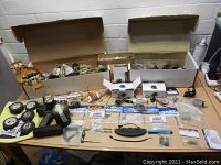 Full display of all RC car frames, tires, electronic parts, and miscellaneous components laid out on a table.