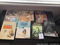 Top-down view of 8 humour books arranged in two rows showing covers including The Far Side Gallery, Calvin and Hobbes, and Herman titles.