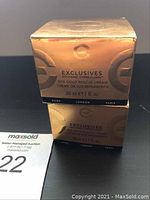 Photo of two gold boxes stacked, showing front of the box with product name: 'Exclusives SOS Gold Rescue Cream 30 ml / 1 fl. oz.'