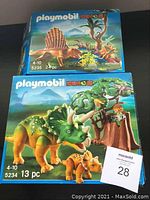 Box and assembled view of Playmobil Dinos sets 5235 and 5234 showing box art featuring Spinosaurus and Triceratops respectively.
