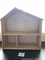Front view of IKEA wooden dollhouse showing interior room divisions and mounting holes.