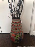 Front angled view of the large vintage ceramic floor vase showing beige fat lava glaze with orange ovals and colorful floral motifs.