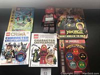 Photo showing five Lego books including Chima and Ninjago titles along with partially visible Lego-themed clock