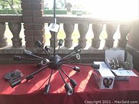 Sputnik ceiling light fixture laid out with arms radiating from a central sphere, showing multiple bulb sockets and ceiling mount plate with hardware.