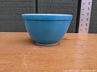 Side view of the blue Pyrex mixing bowl showing slight shelf wear and the glossy finish.