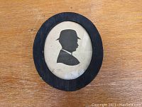 Front view of framed silhouette artwork showing gentleman in derby hat profile.