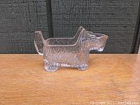 Side view of clear glass Scotty dog creamer showing textured fur and defining features.