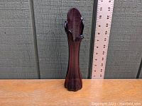 Front view of the amethyst swung glass vase with ruler showing approximately 10 inches height