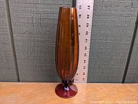 Front view of the tall amber glass Empoli vase next to a ruler showing approx 38 cm height.
