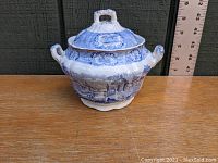 Front view of the blue and white ceramic sugar bowl with lid and ruler for measurement reference.